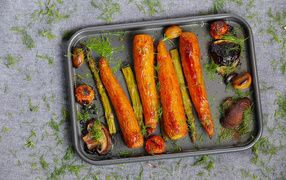 Baked carrots with asparagus and mushrooms on a baking sheet