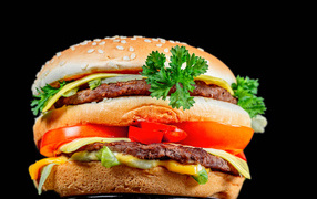 Big hamburger with cutlet on black background