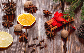 Cinnamon on a table with nuts, star anise, dried oranges and cloves