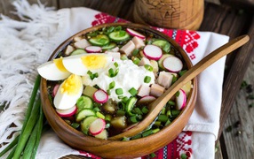 Cold okroshka in a wooden bowl on the table