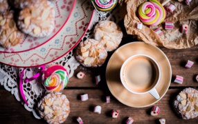Чашка кофе на столе с печеньем и конфетами