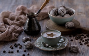 Чашка кофе на столе с пряниками и зернами