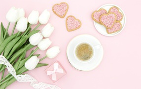 Чашка кофе с печеньем на столе с букетом белых тюльпанов