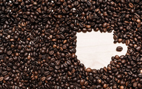 Рисунок чашки из кофейных зерен на столе