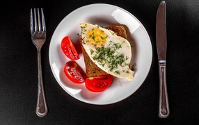 Egg sandwich on a plate with tomatoes