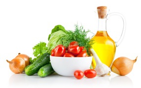 Fresh vegetables on a table with olive oil on a white background