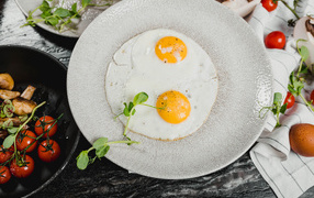 Fried eggs with vegetables on the table