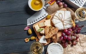 Виноград на столе с сыром, хлебом и оливками