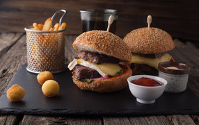 Hamburgers with meat on the table with fries and sauce