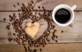 Heart-shaped cookies on a table with grains and a cup of coffee