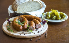 Homemade sausage on a table with bread and pickles