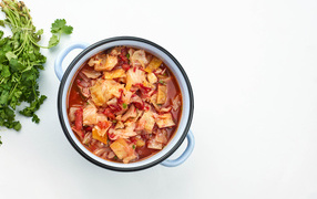 Горячие щи в кастрюле на столе с петрушкой