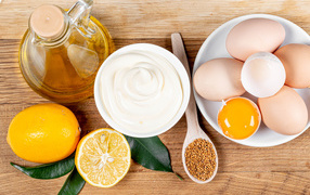 Ingredients for homemade mayonnaise on a wooden table.