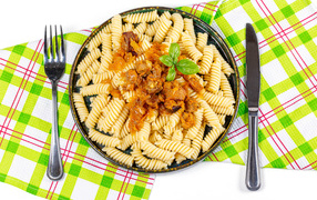 Large plate of pasta with meat on the table with cutlery