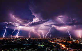 Lightning pierces a stormy sky over a night city