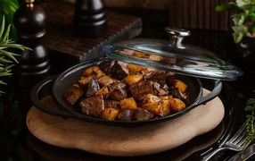Liver with potatoes in a pan on the table