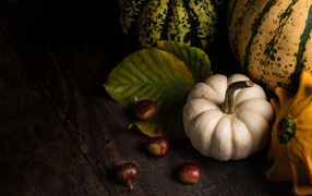 Pumpkin with chestnuts on a wooden table