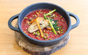 Красный суп с мясом на доске 