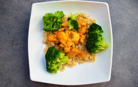 Рис с мясом и брокколи в белой тарелке 