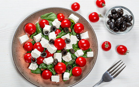 Salad with cherry tomatoes, olives, basil and cheese