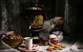 Самовар стоит на столе с чаем и баранками