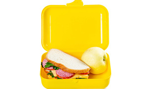 Бутерброд и яблоко в контейнере на белом фоне