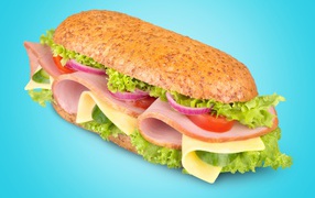 Sandwich with ham, cheese, tomato onions and lettuce on a blue background