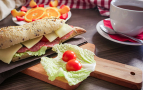 Sandwiches on a table with fruits and a cup of tea