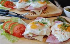 Бутерброды с яичницей и беконом на столе с овощами