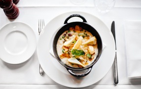 Суп в миске стоит на белой тарелке 