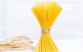 Spaghetti tied with a thread on a white background
