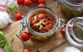 Sun-dried tomatoes in oil in a glass jar on the table