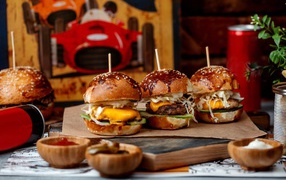 Вкусные гамбургеры на столе с соусом и кока колой 