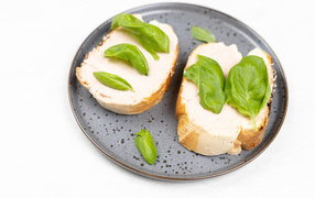 Два бутерброда с листьями базилика 