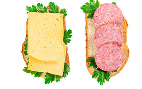Two sandwiches with cheese, sausage, parsley on a white plate