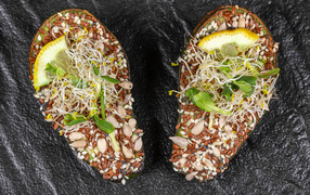 Половинки авокадо с проросшими зернами на столе