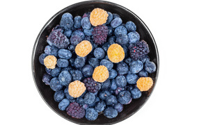 Миска с замороженными ягодами черники и ежевики на белом фоне