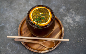 Чашка холодного чая со льдом и кусочком апельсина