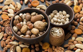 Разные виды орехов на столе в мисках 