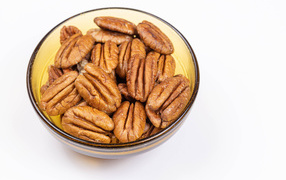 Ядра орехов в миске на белом фоне