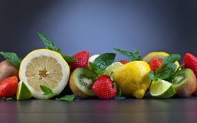 Лимоны на столе с киви и ягодами клубники 