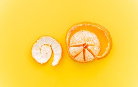 Очищенный мандарин с кожурой на желтом фоне 