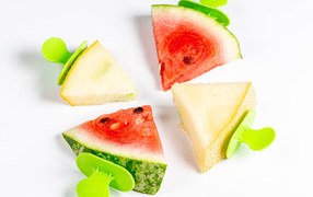 Кусочки арбуза и дыни на палочках на белом фоне