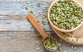 Тыквенные семечки в деревянной посуде на столе