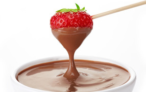 Спелая клубника в молочном шоколаде на белом фоне