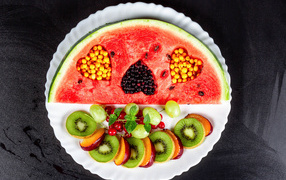 Арбуз на тарелке с ягодами 