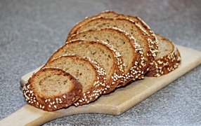 Свежий хлеб нарезан на доске на столе 