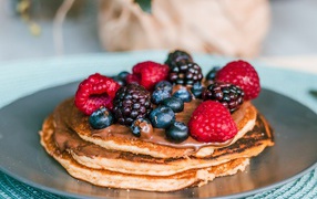 Rosy pancakes with berries on a plate