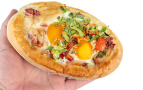 Вкусный свежий хачапури с яйцом и беконом в руке