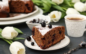 Кусок пирога со смородиной на столе с тюльпанами 